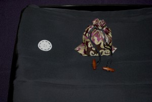 An image of a decorative bag containing a wooden stamp called an Inshō and a traditional folded Japanese outfit known as a Haori.